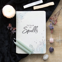 Load image into Gallery viewer, My Book Of Spells A5 Notebook.  Keep track of spells, rituals and intent in this A5 Book of Spells notebook with lined pages. Features a mystical hand and blue watercolour design on the cover that&#39;s perfect for any modern witch.